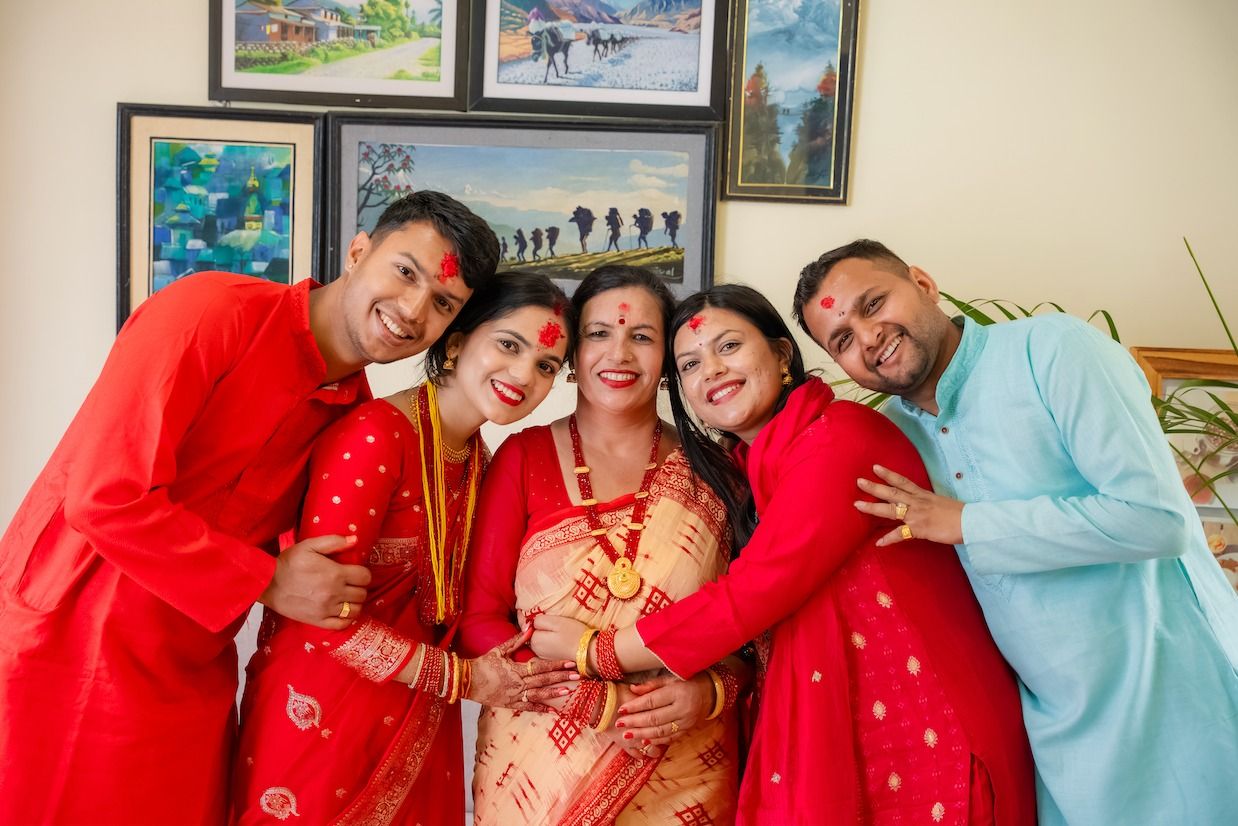 Maya with her family, all dressed in festive red and smiling together