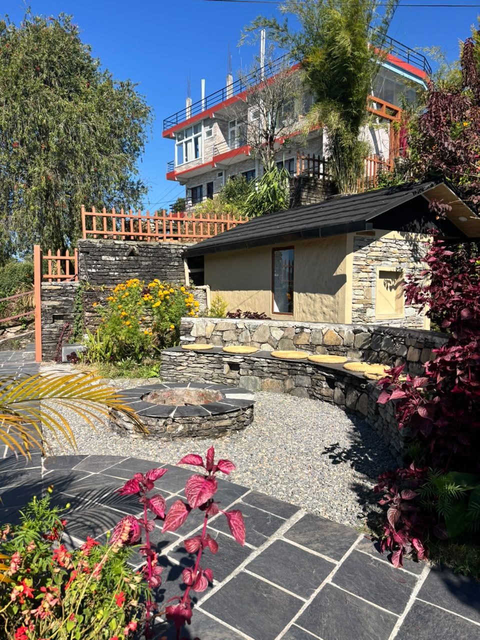 A stone fire pit and curved stone bench in the garden
