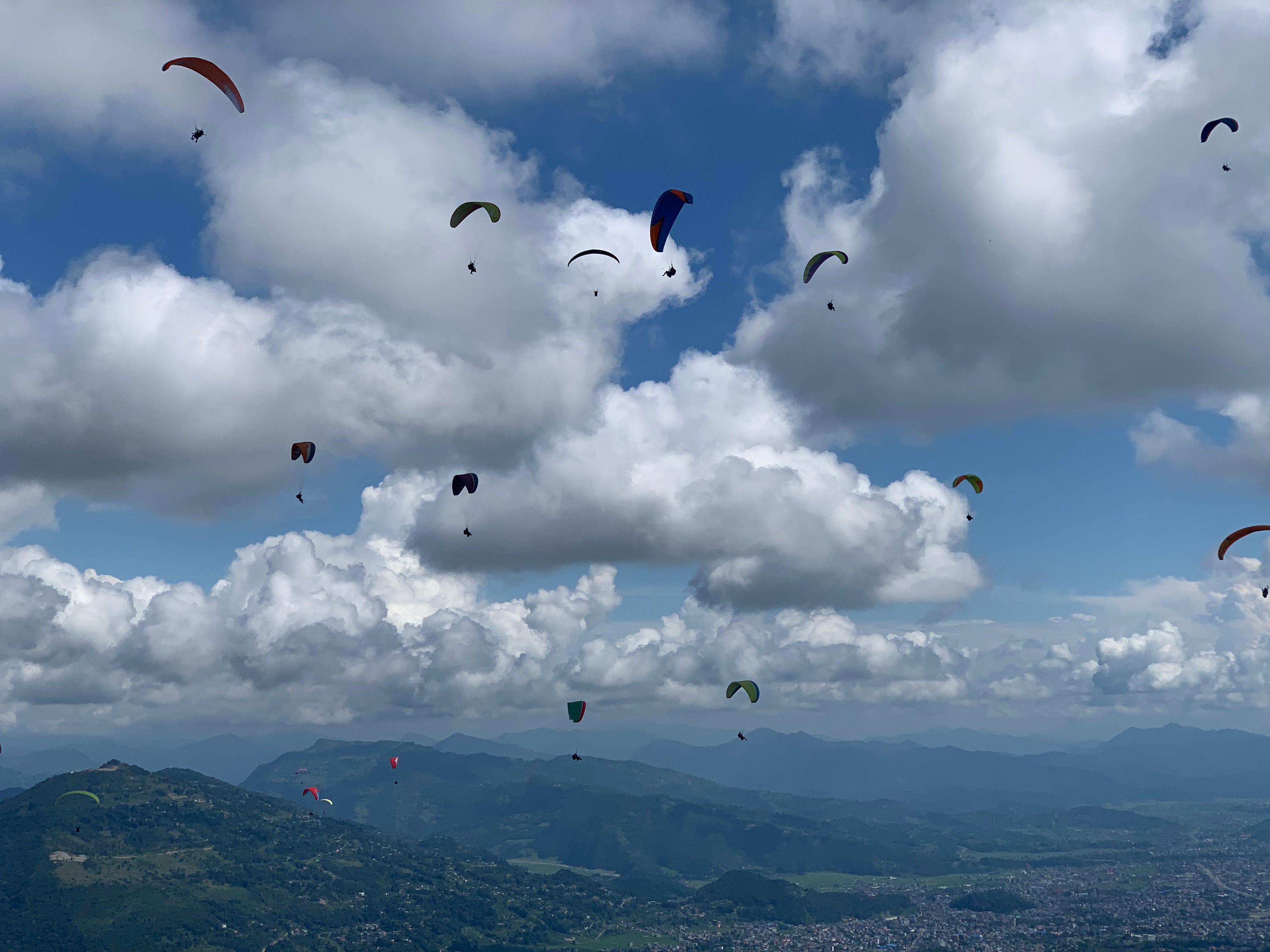 Paragliders over the valley at dusk