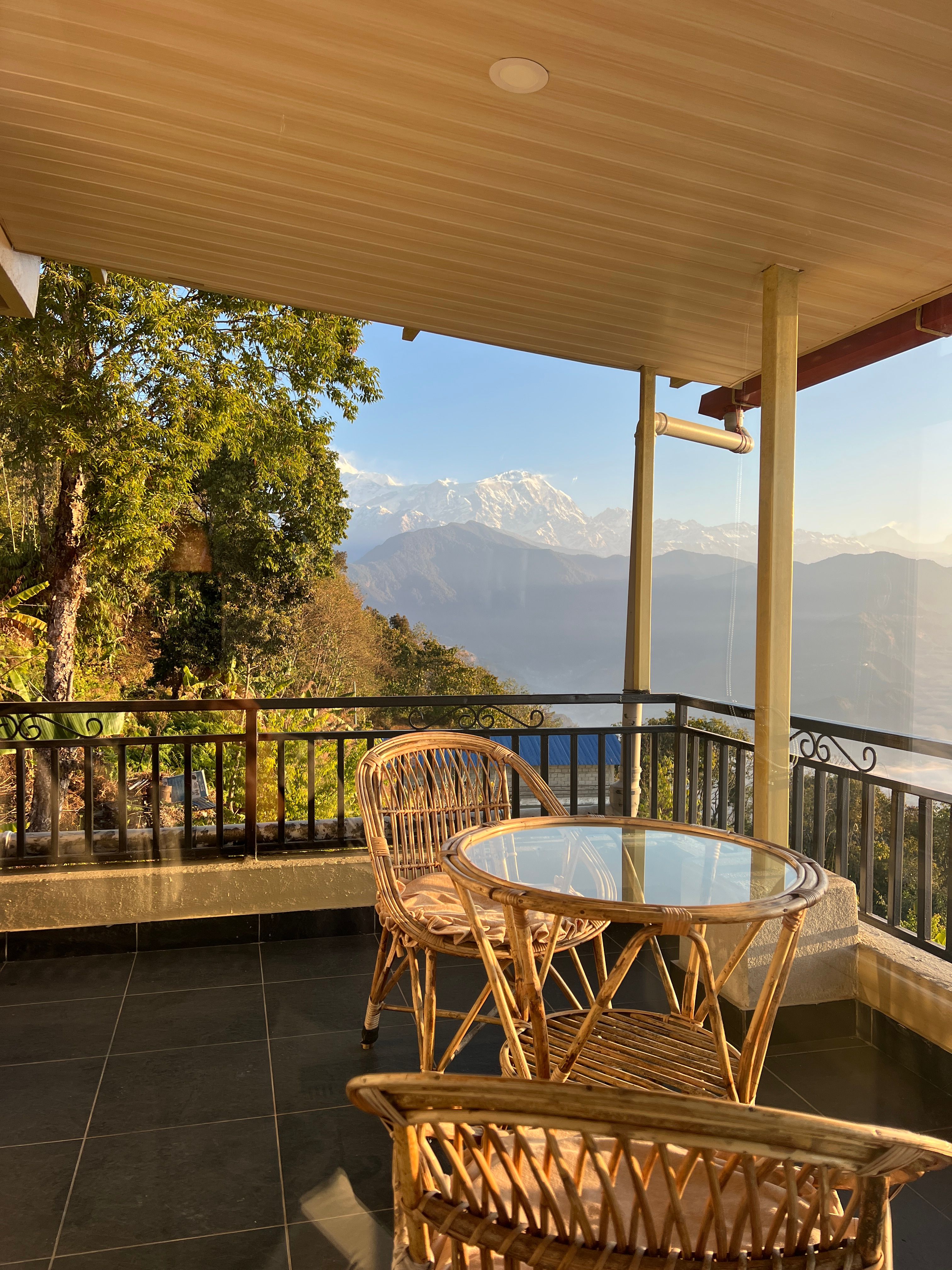 Cane chairs on the apartment balcony, with the snowy Annapurna range behind