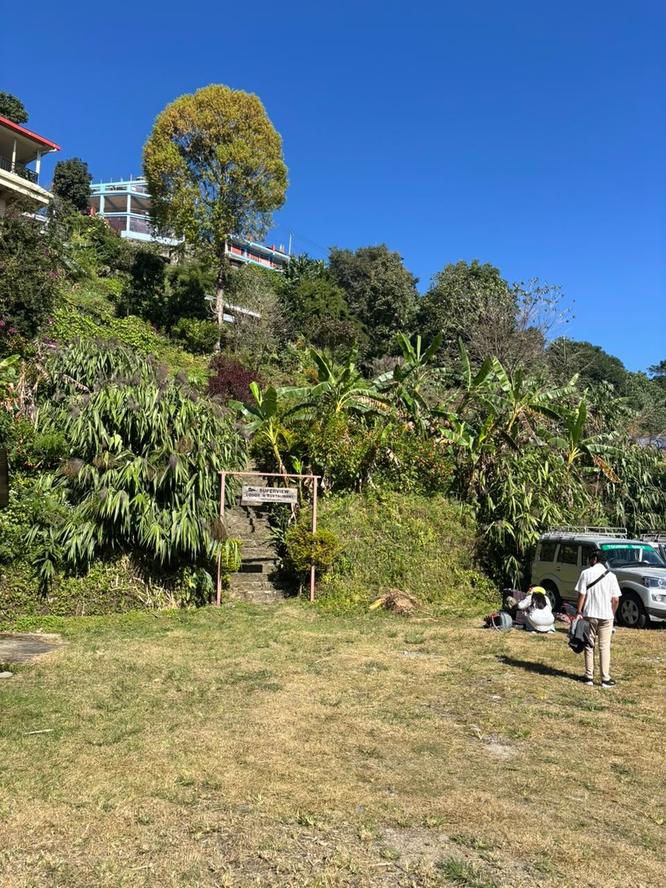 Our private parking: a grassy lot with jeeps, mountains behind