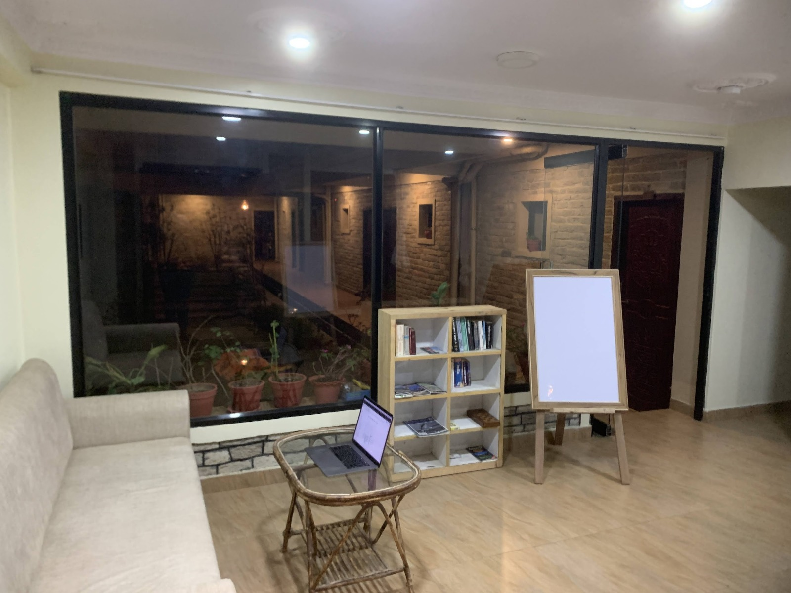 A sitting room with a desk, sofa and bookshelf
