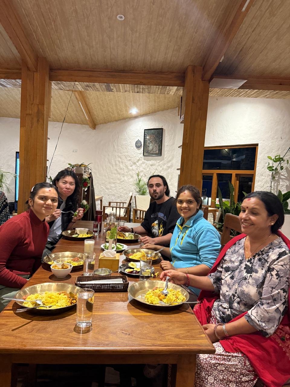 Guests and the family around one table at the evening set dinner
