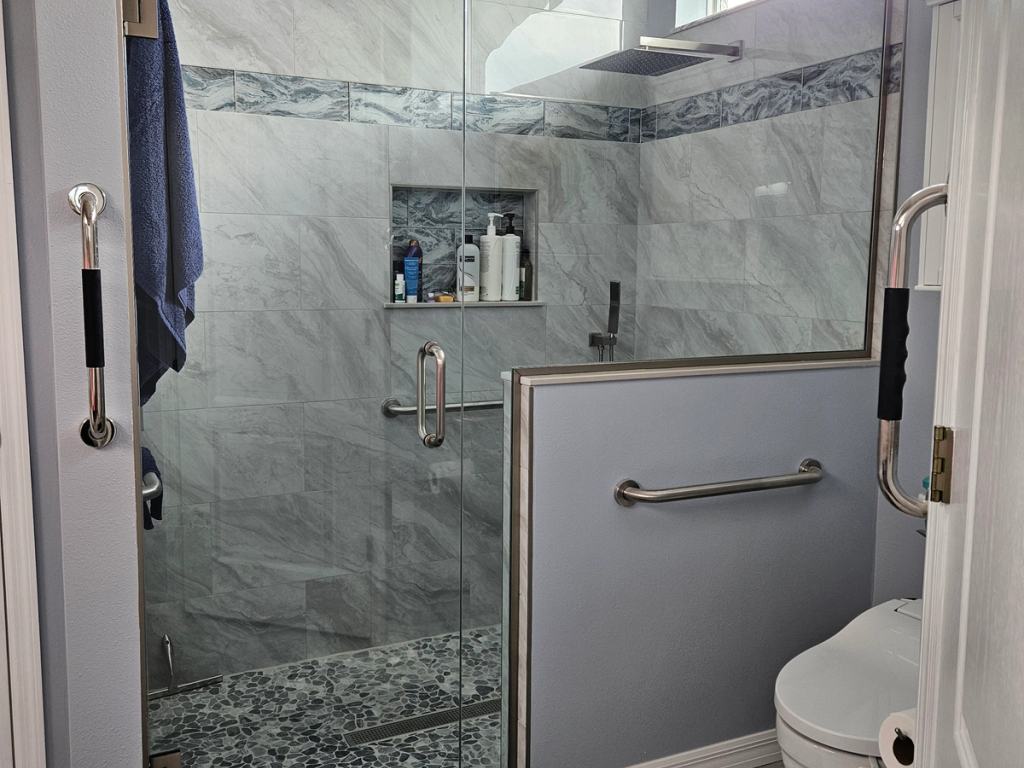 New ADA compliant bathroom with grab bars and custom shower glass door.
