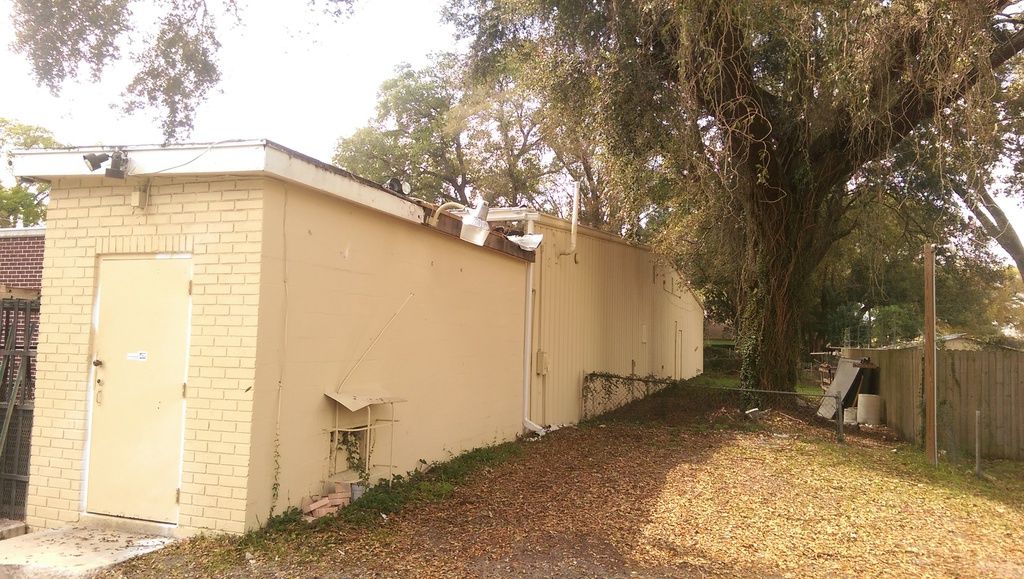 Another section of the old roof before replacement, showing worn, faded panels.