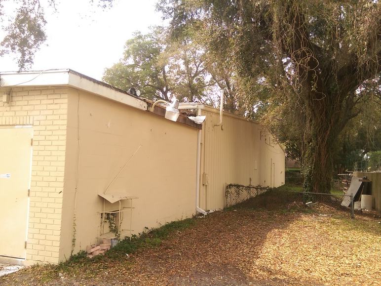 Another section of the old roof before replacement, showing worn, faded panels.