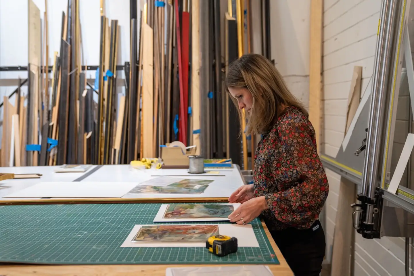 Frame House co-founder Lily Trest measuring artwork for framing