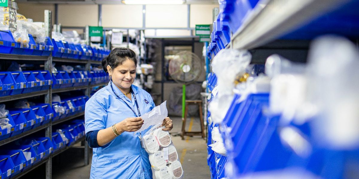 Warehouse staff checking items on a rack against a printed stock list, the situation that appears when records still live in a spreadsheet