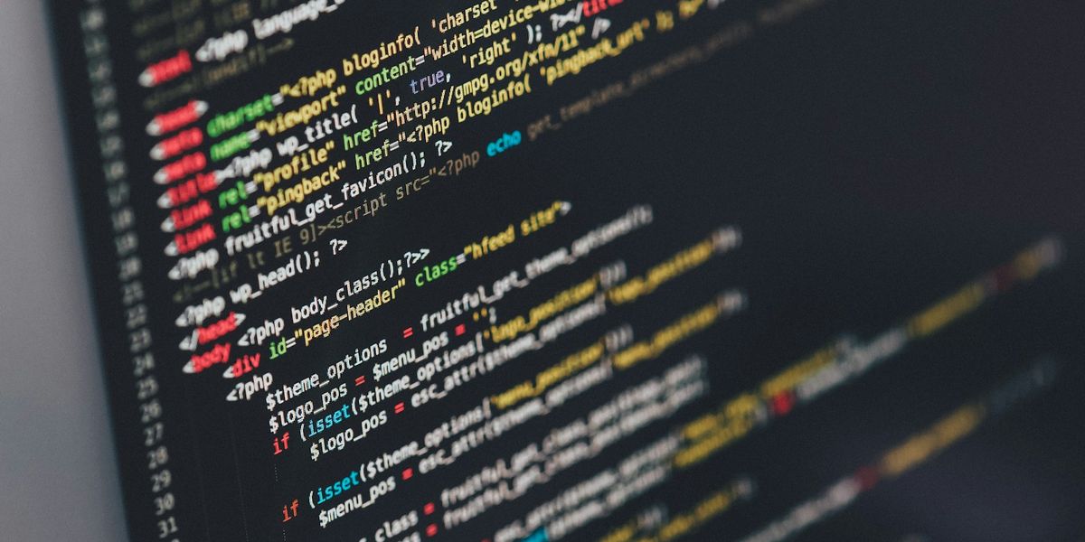 A monitor showing the PHP code of a WordPress theme, the kind of upkeep work covered by a website maintenance cost per year