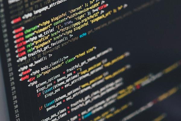 A monitor showing the PHP code of a WordPress theme, the kind of upkeep work covered by a website maintenance cost per year