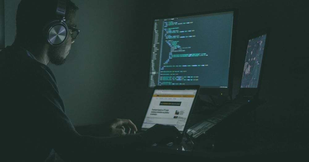 IT security team monitoring digital systems and threat dashboards in a modern operations center