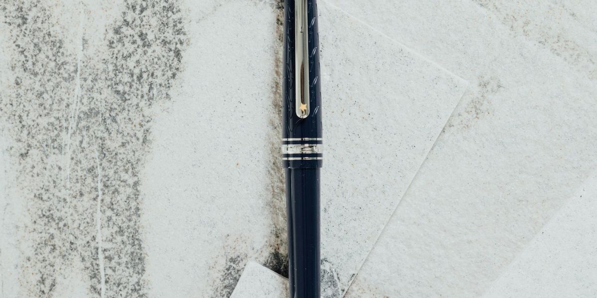 A dark fountain pen lying across sheets of pale paper, the handwritten signature that an electronic signature replaces on a PDF