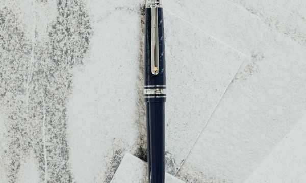 A dark fountain pen lying across sheets of pale paper, the handwritten signature that an electronic signature replaces on a PDF