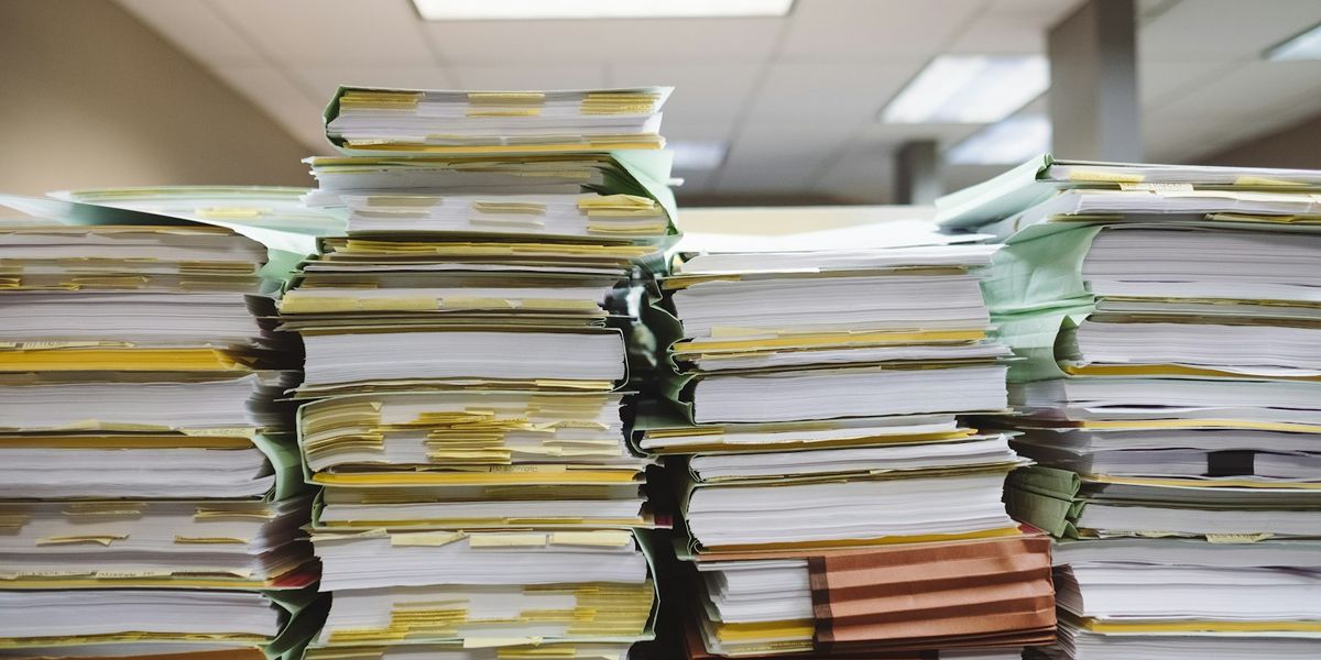 Stacks of paper files and customer records on an office desk, illustrating Indonesia personal data protection law compliance and the duty to map and secure personal data