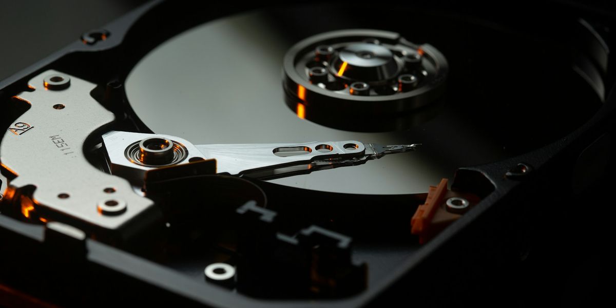 Open hard disk platter and read arm, illustrating the physical hardware a company maintains itself when it chooses an on-premise server over cloud