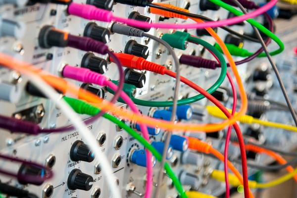 Colour-coded network patch cords plugged into a patch panel in an office equipment rack