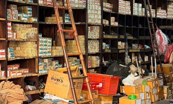 Wall of wooden pigeonhole shelves in a hardware shop packed with small boxes of fasteners and hand-written labels, the kind of stock a POS and an inventory system have to agree on