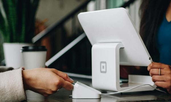 Pelanggan menempelkan kartu ke mesin pembaca di samping tablet kasir di meja toko kecil, contoh langkah digitalisasi UMKM dari nol lewat pembayaran non-tunai
