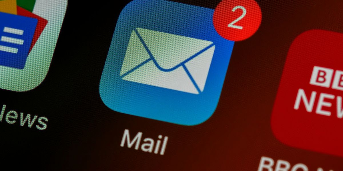 Ikon aplikasi email di layar ponsel dengan penanda pesan belum dibaca, ilustrasi kotak surat perusahaan yang memakai domain sendiri