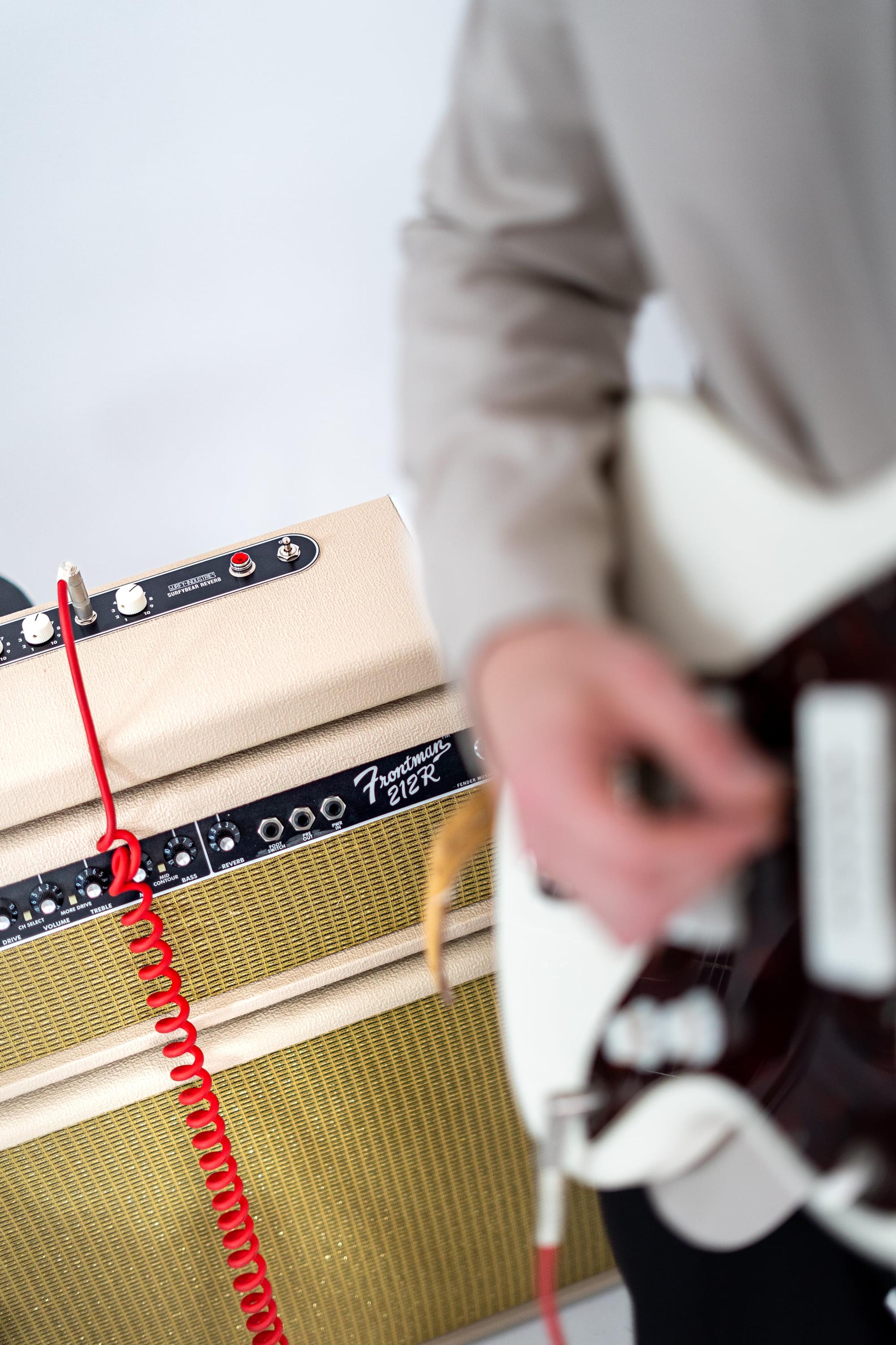 Dłonie gitarzysty przy wzmacniaczu, zbliżenie
