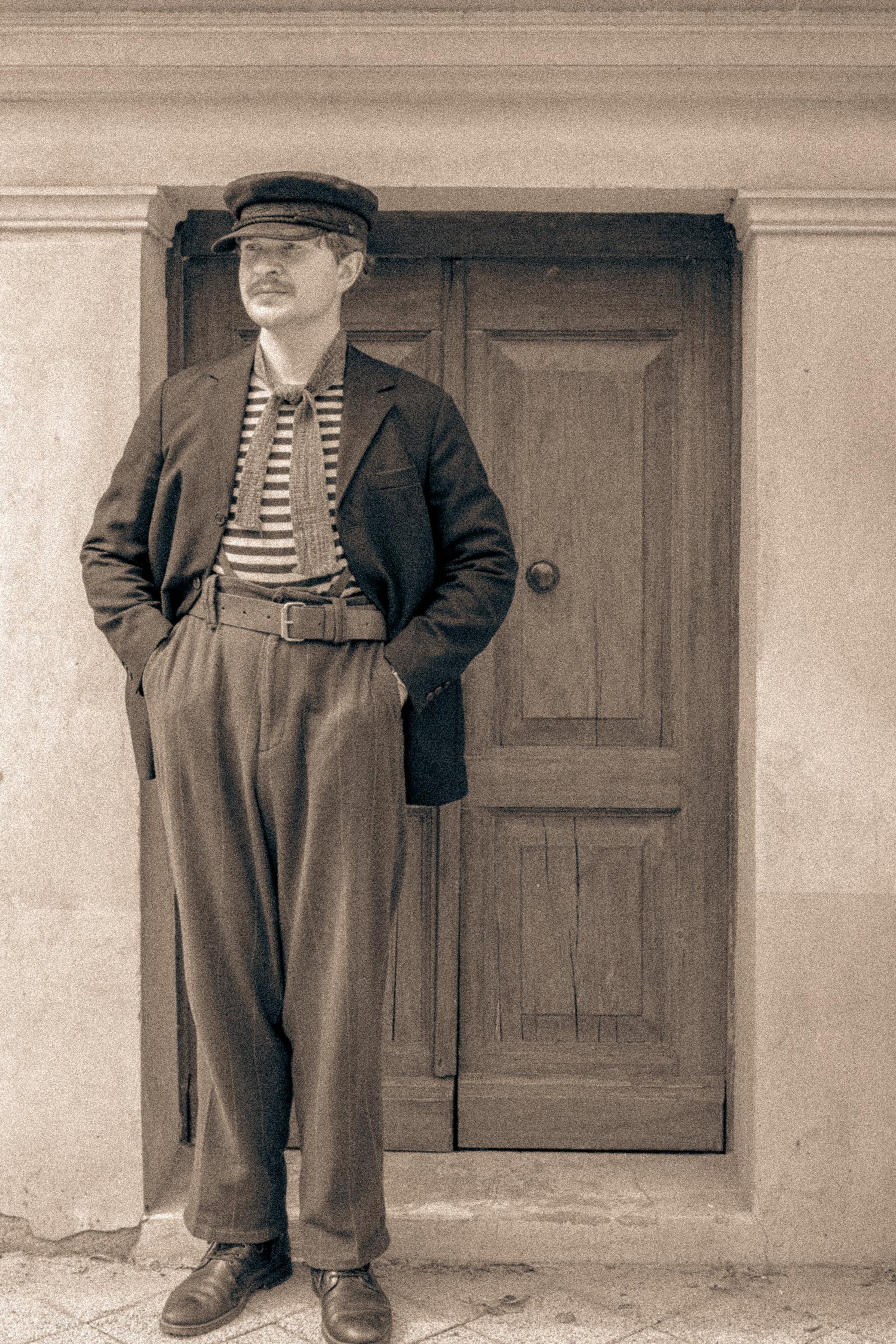 Mężczyzna w marynarce i pasiastej koszulce, kadr bez twarzy, sepia
