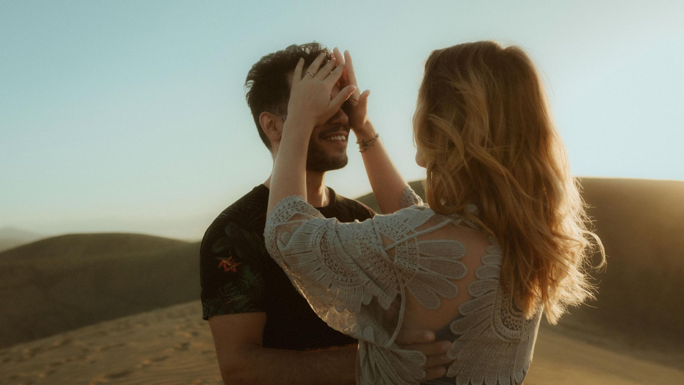 Katja playfully covering David's eyes while he smiles.