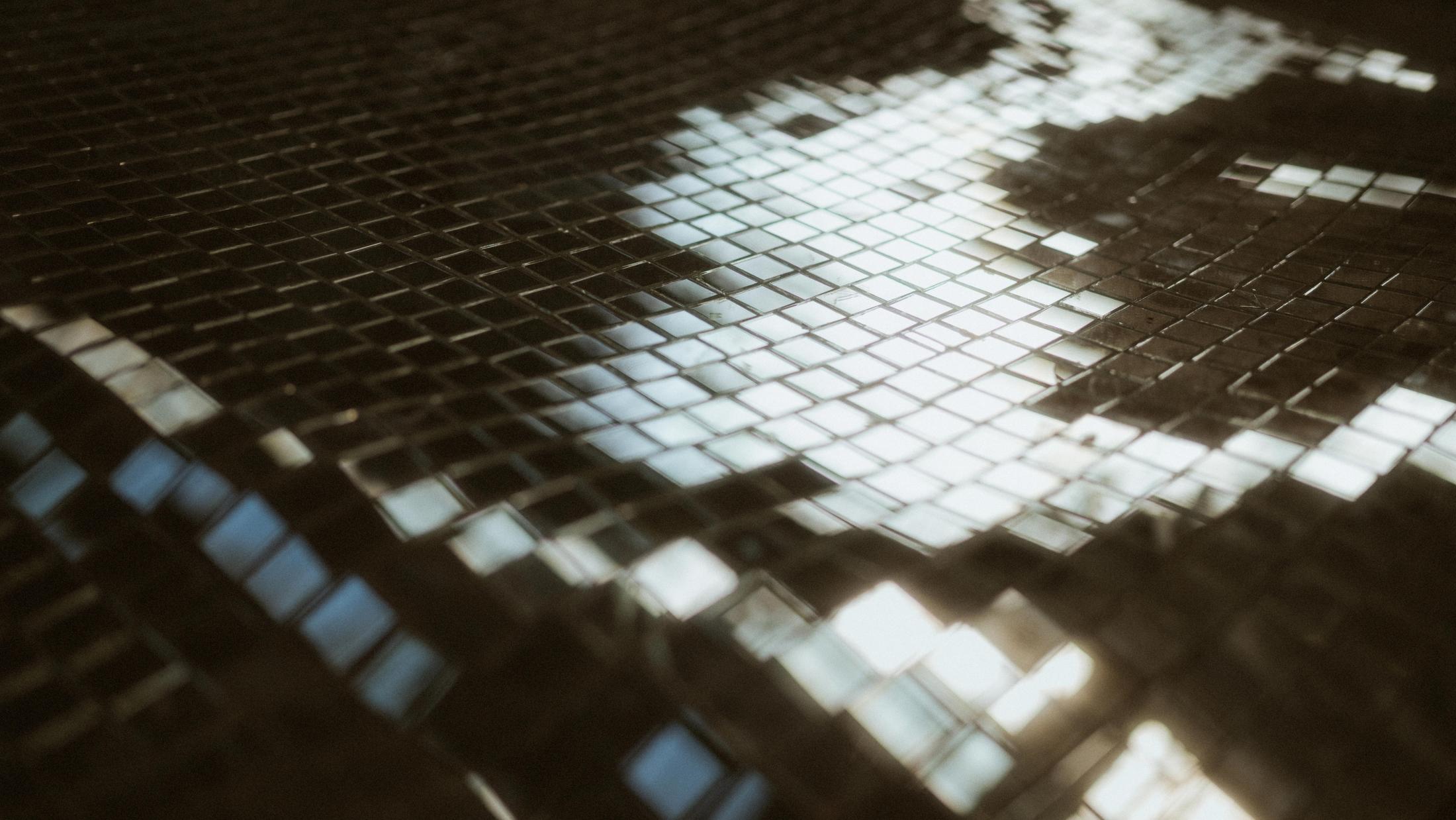 Abstract reflection of Mahalla's glass roof in small mirrored tiles.