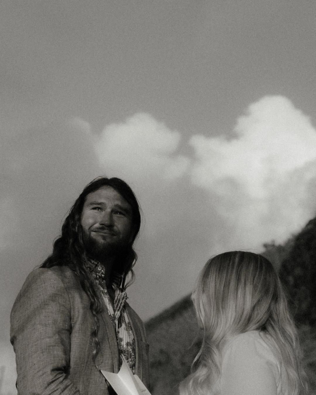 Gary looks upward with visible emotion while Twyla stands before him in black and white.