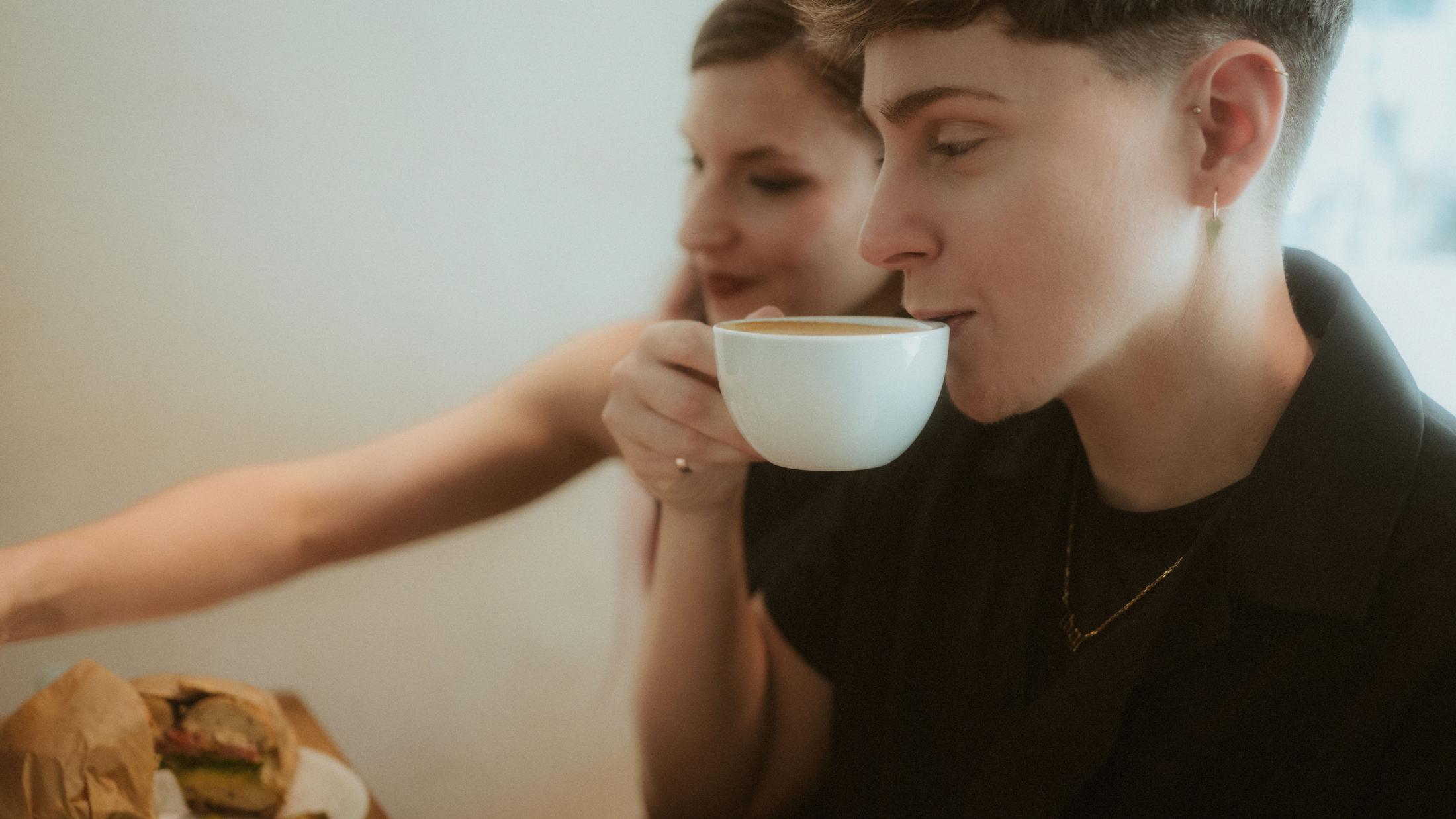 Noah and Michèle sharing coffee and food at a Berlin café table.