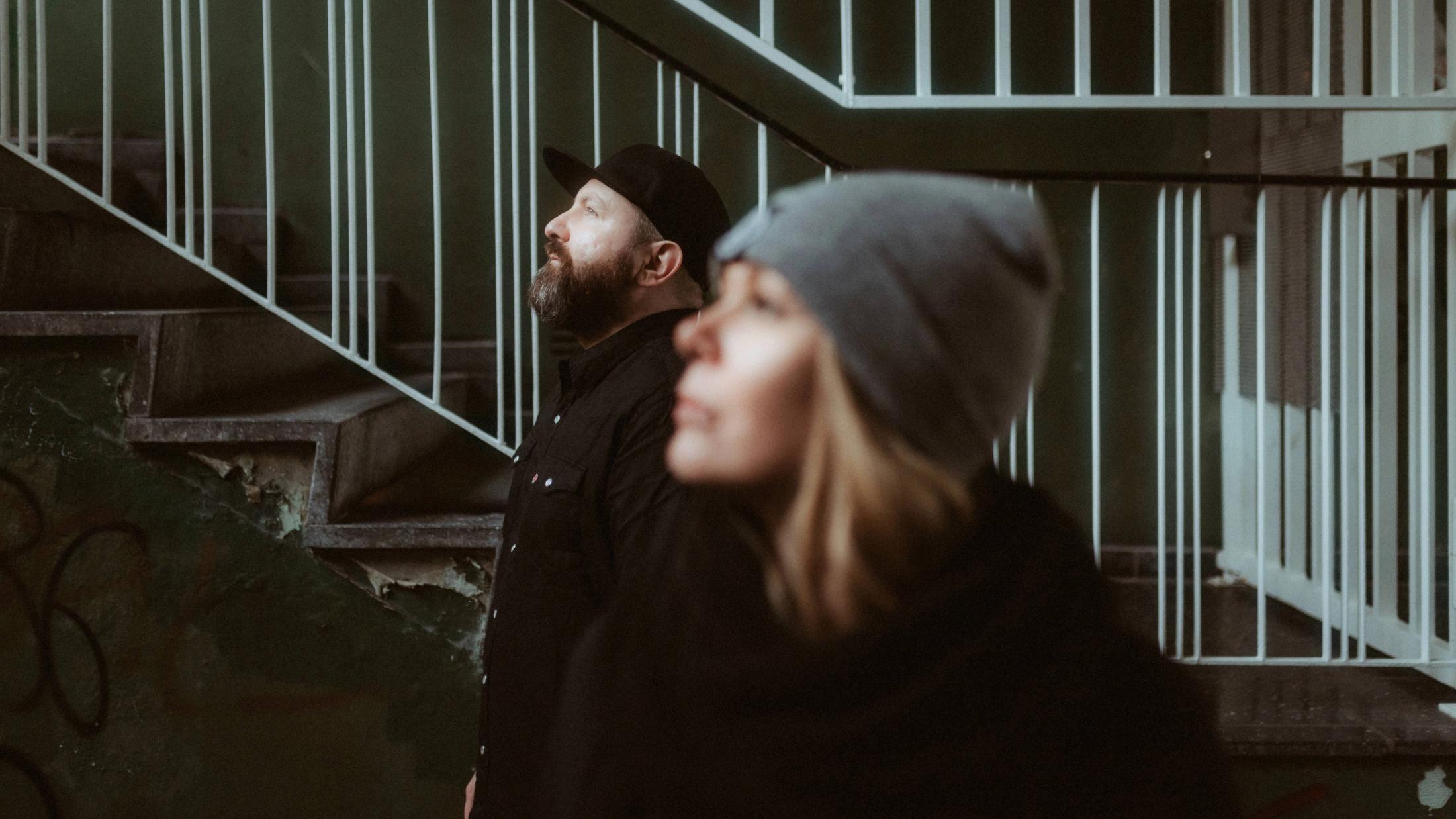 Debbie and Fabi look in different directions between metal stairways.