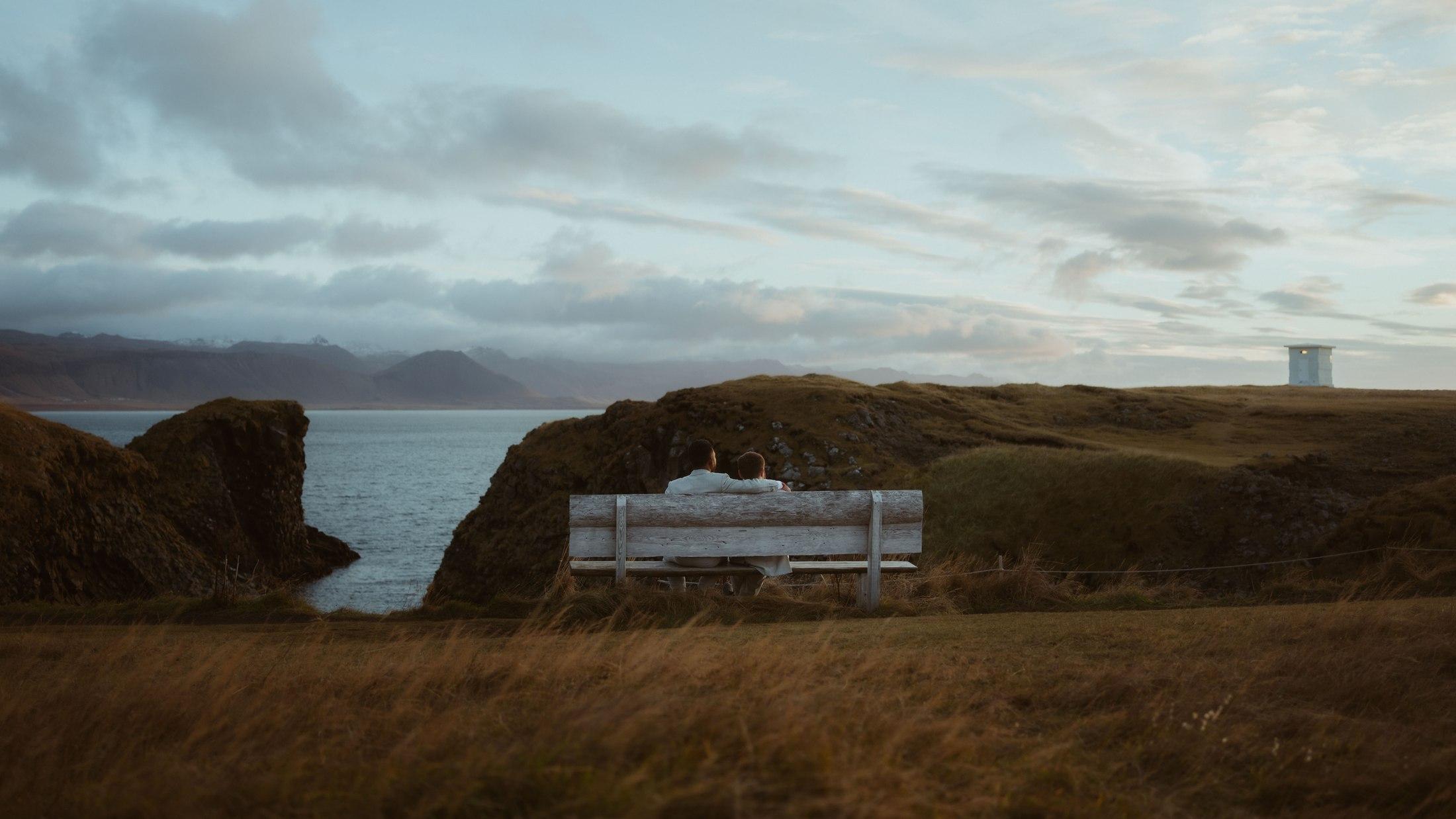 A bench overlooking a natural rock arch and the sea at Arnarstapi.