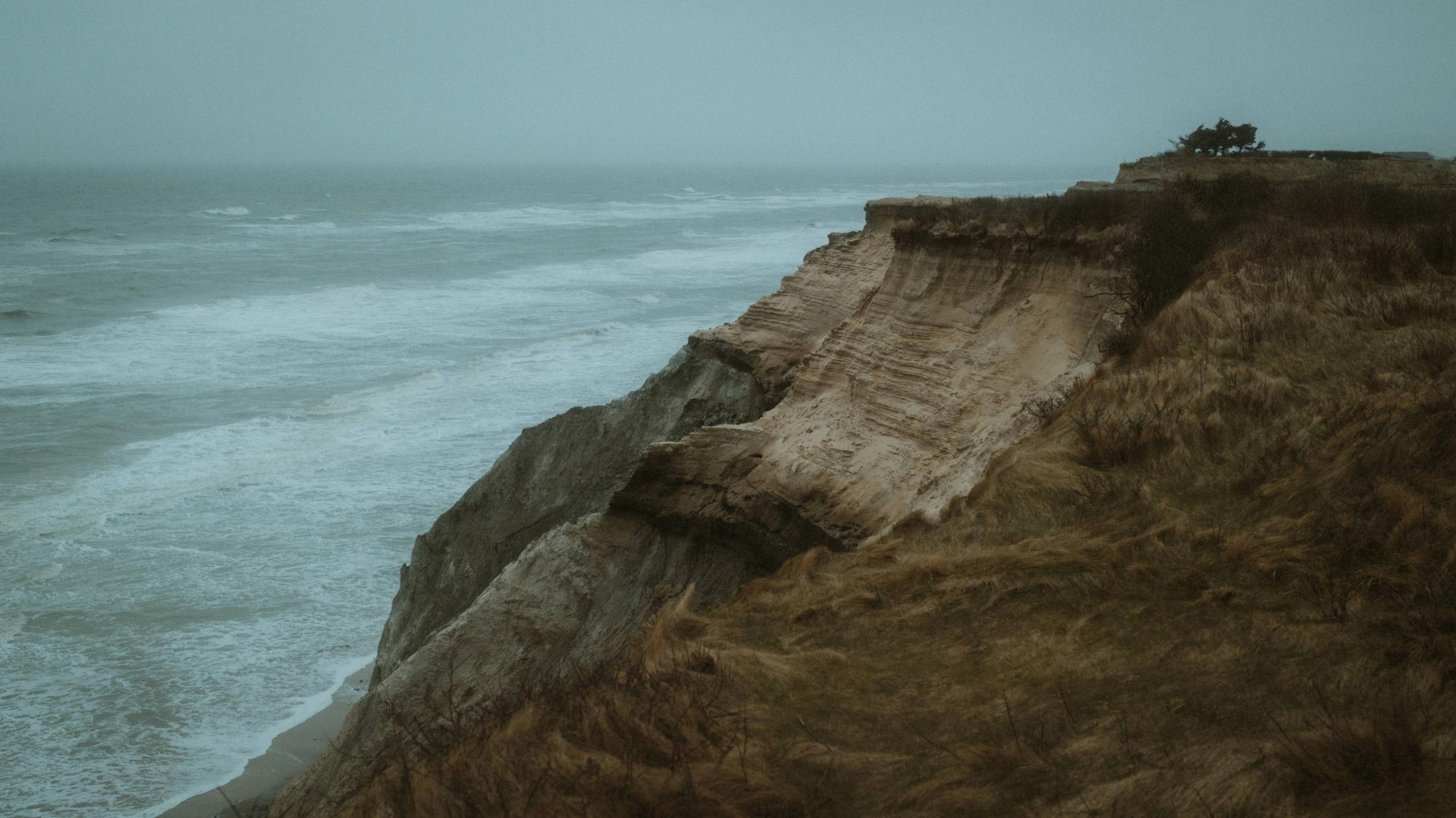 Eine erodierte dänische Klippe fällt zur rauen Nordsee ab.