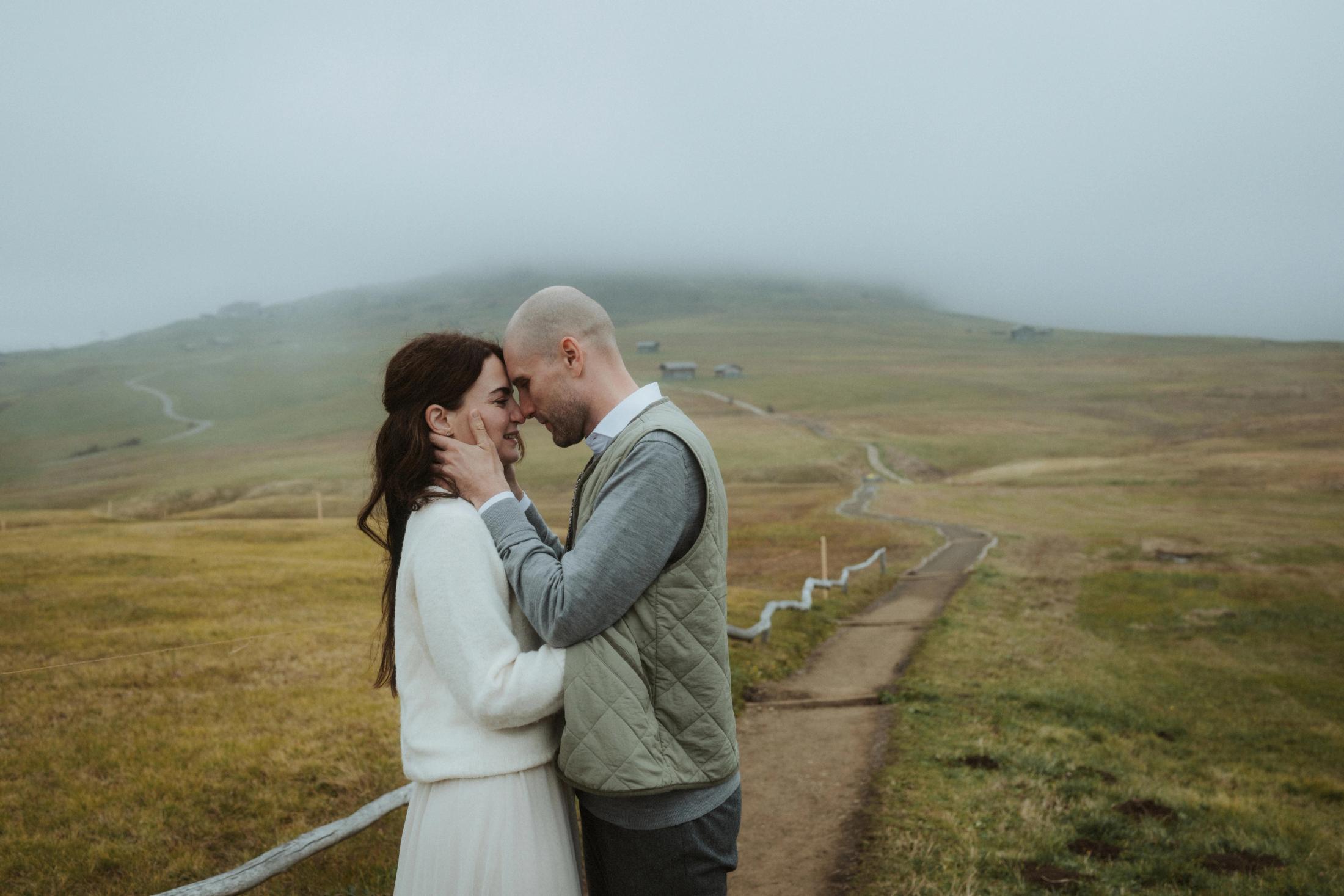 Jana and Steffen kissing on a foggy mountain path.