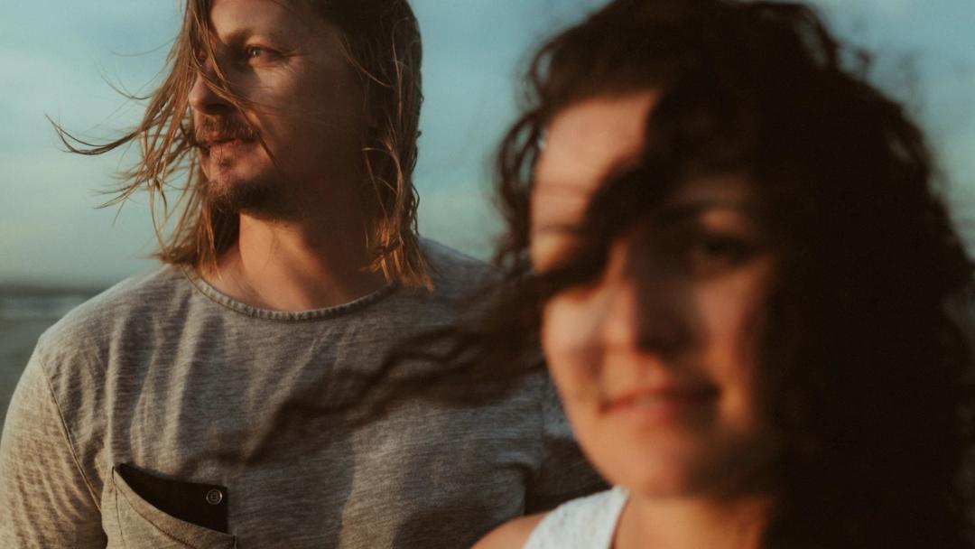 Windblown close portrait of Roman and Petra by the ocean