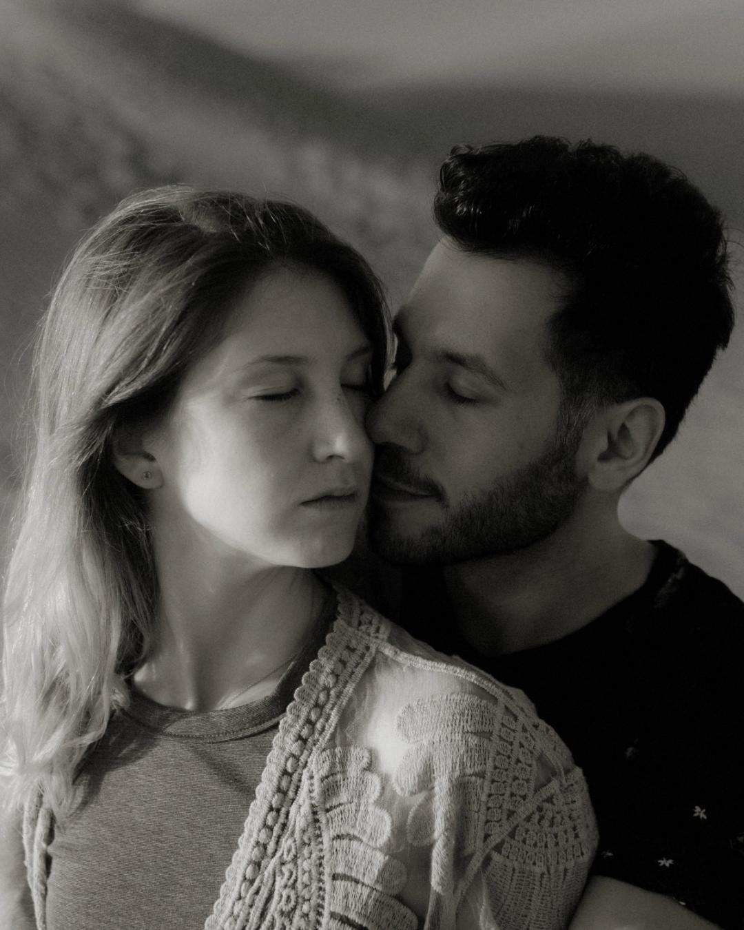 Black-and-white close-up of David kissing Katja's cheek.
