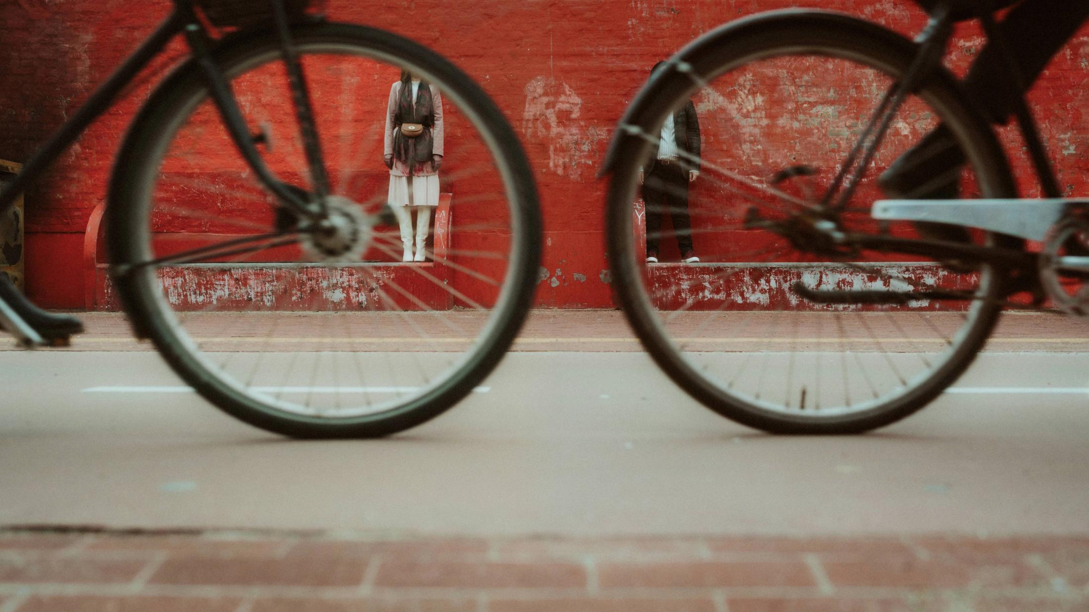 A cyclist crossing a red wall in Copenhagen