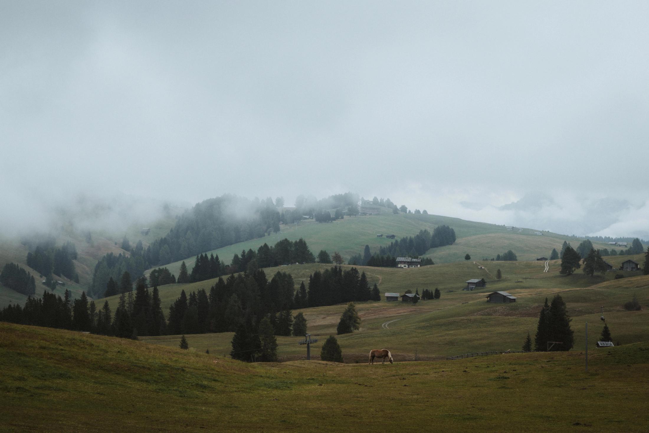 Wide view across Seiser Alm before dense fog covers the hills.