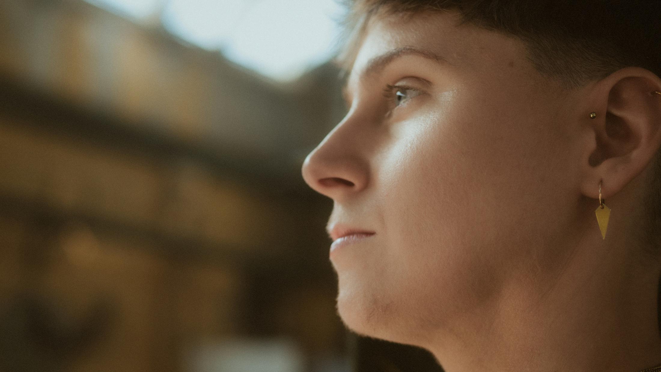 Noah in profile with the Mahalla hall softly visible behind them.