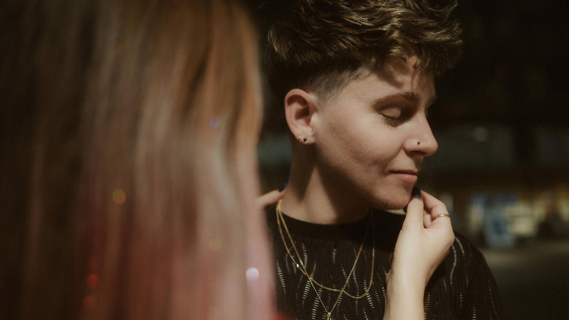 Michèle gently touching Noah's face in warm light.