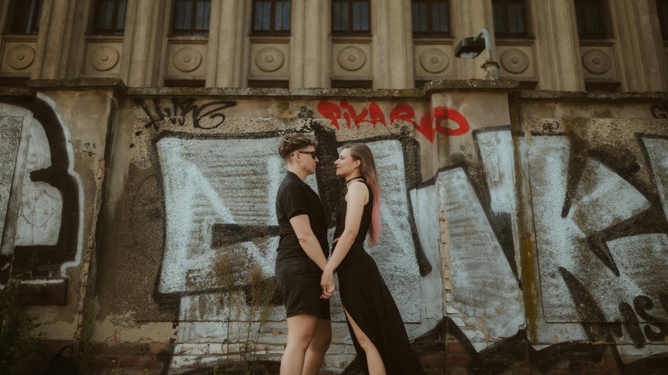 Noah and Michèle facing each other beneath the large PAIN lettering.