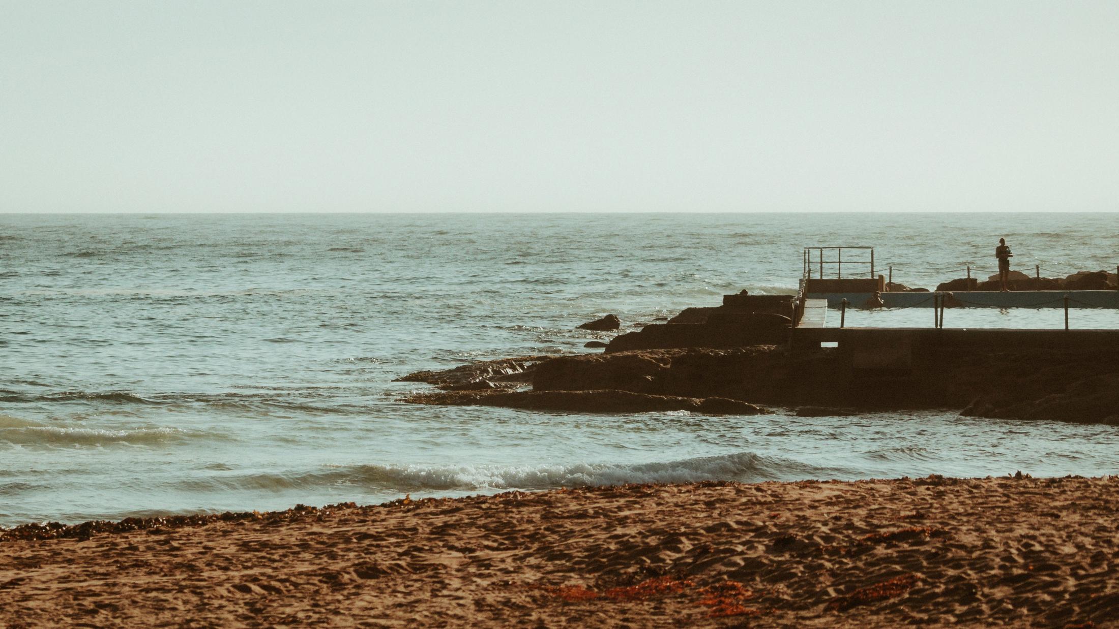 Wide view of Palm Beach, the ocean and the stone pool near shore