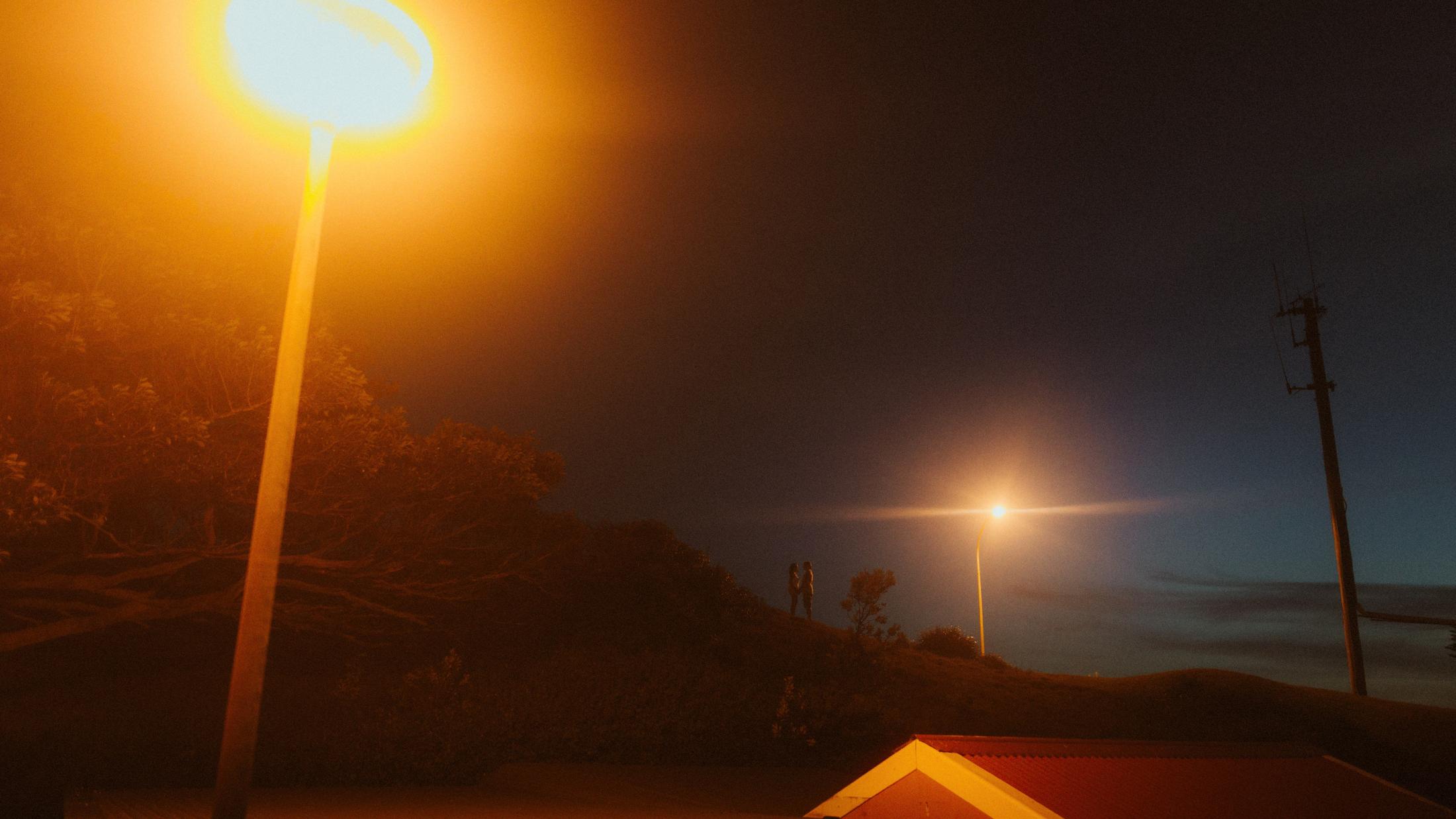 Beach lights glowing against the darkening sky