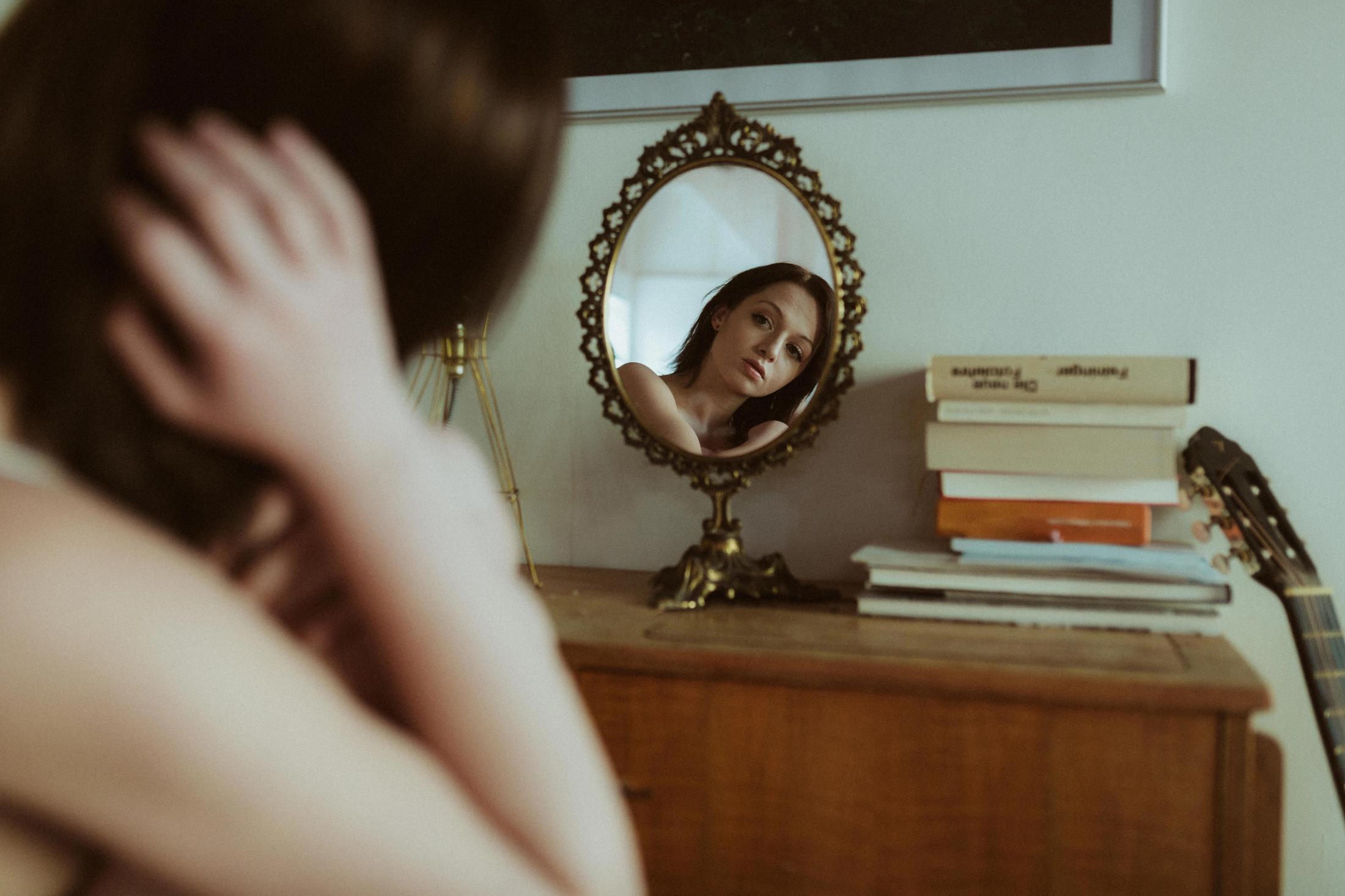 Woman reflected in a small mirror across a room