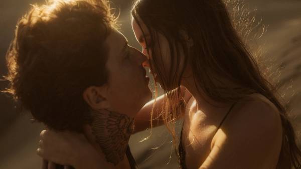 Angela and Ivan kissing in warm backlight at sunset.