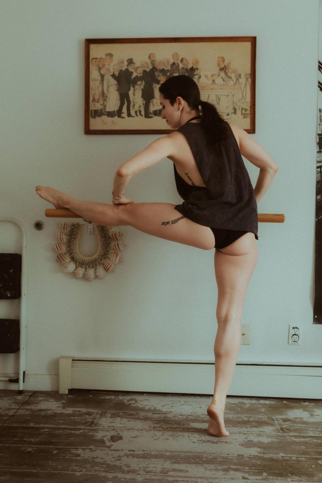 Maya holding a precise dancer’s pose beside framed wall art.