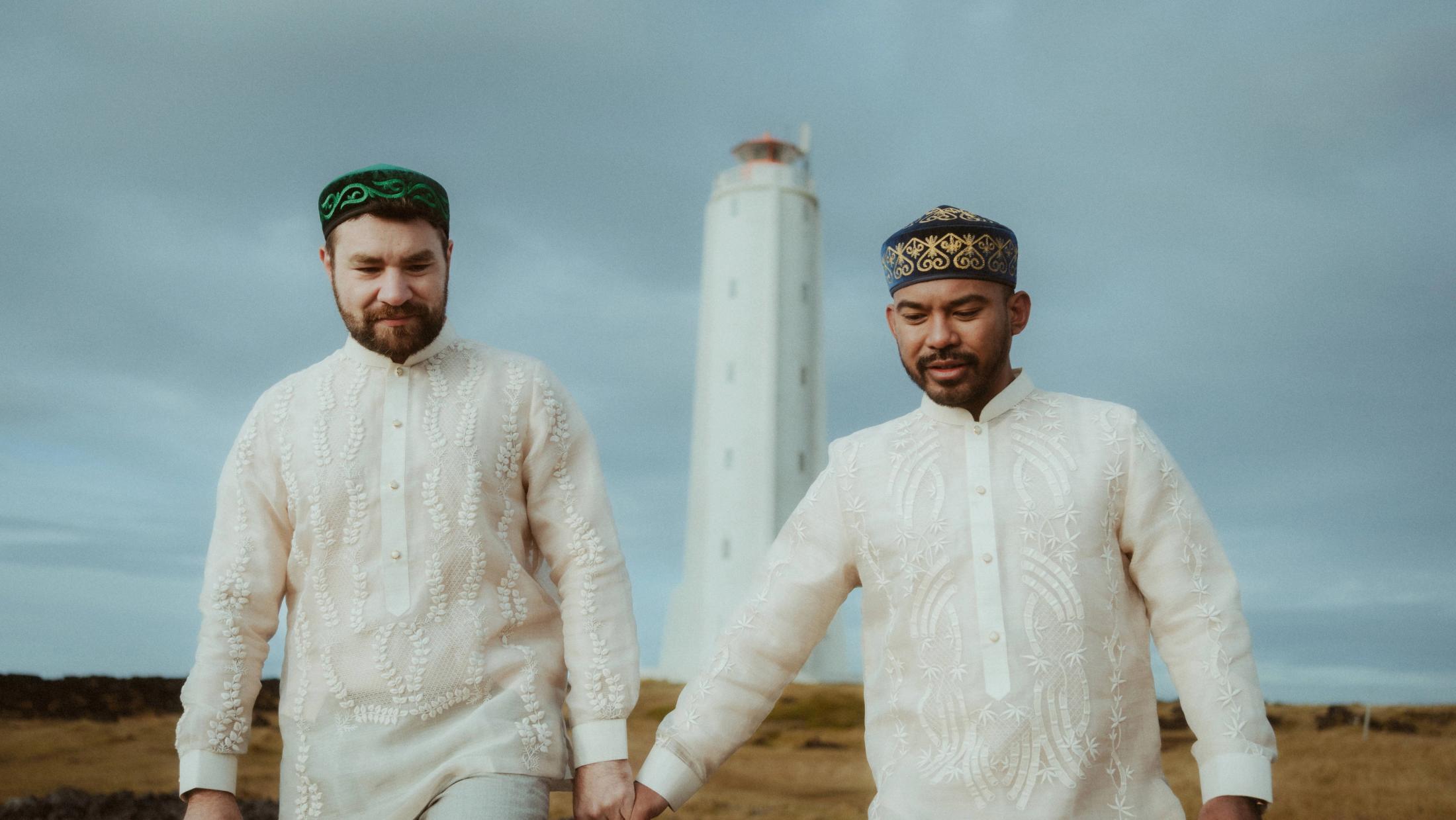 Kris und Ilya stehen vor dem Leuchtturm in einem Barong Tagalog und traditioneller bestickter Kleidung.