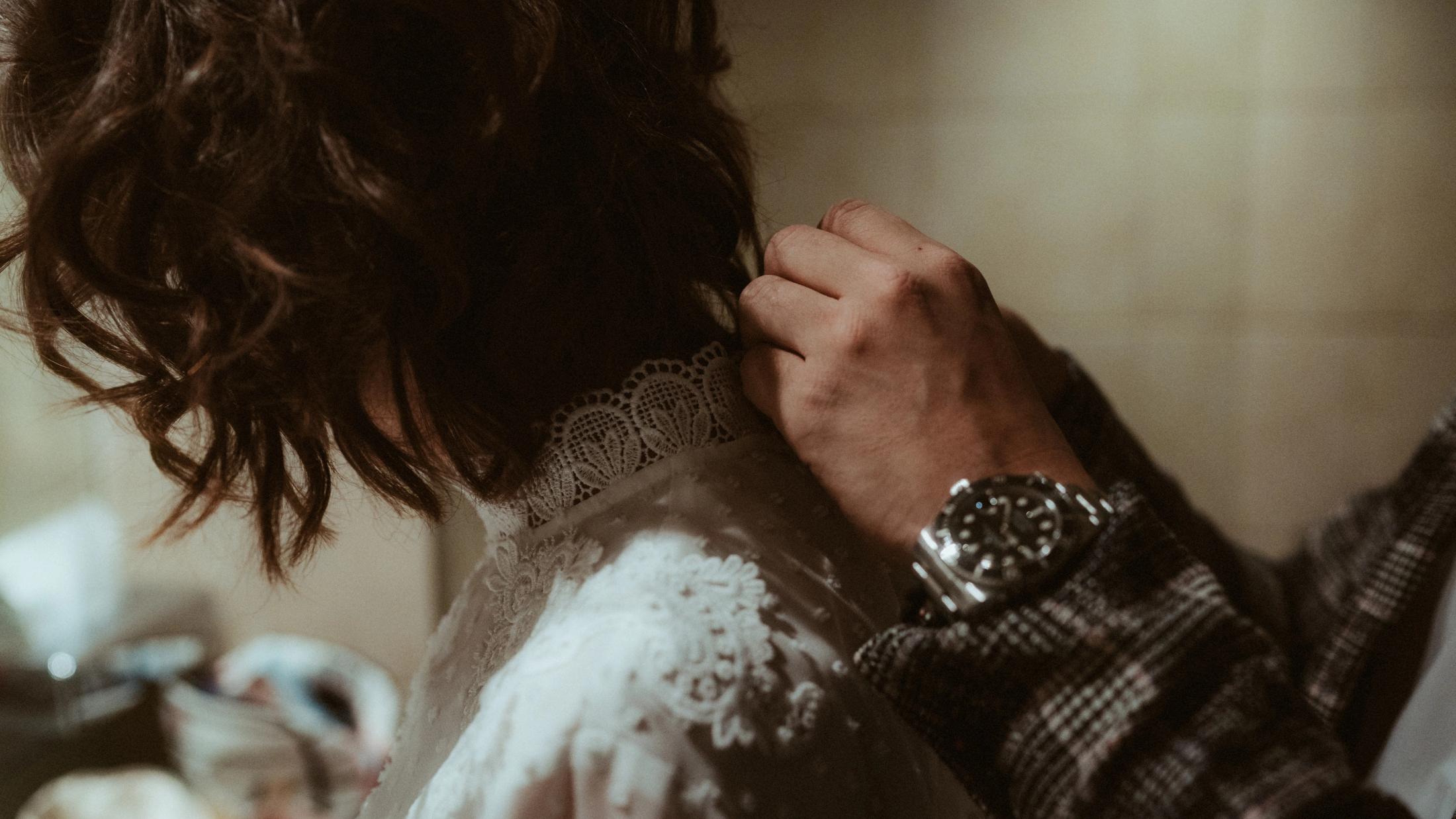 Close view of hands fastening a lace collar