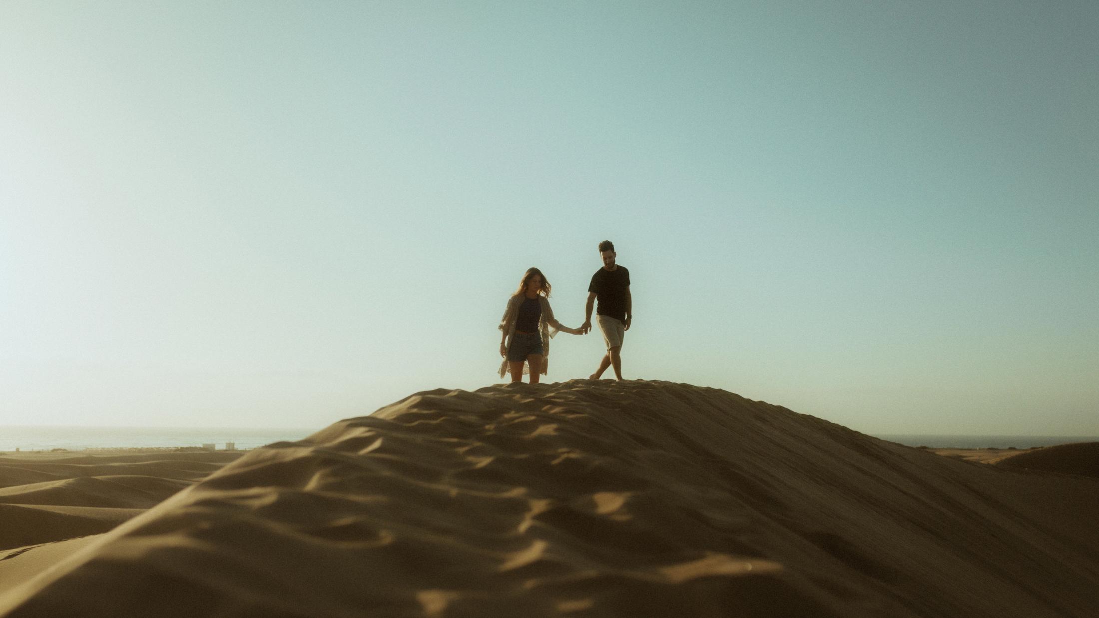 Katja and David standing together on the crest of a dune.