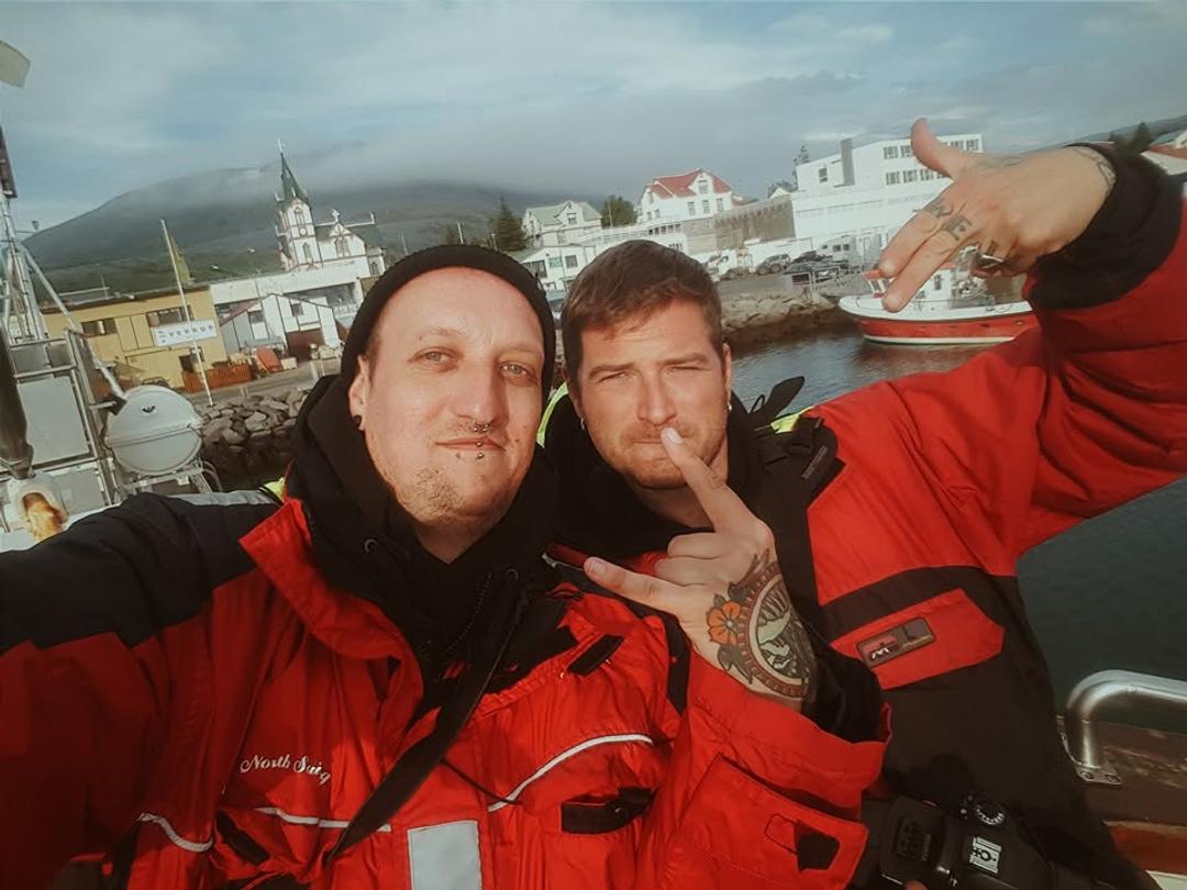 Bjørn and Josh wear red protective suits while whale watching in Iceland.