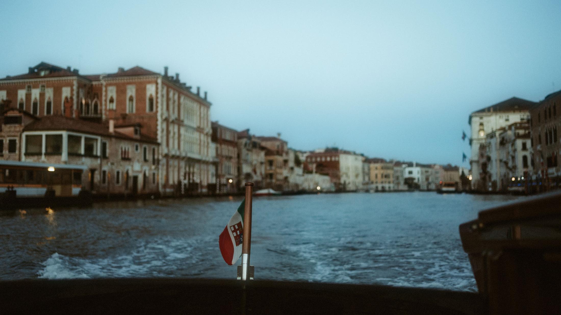 View from a moving boat across the Grand Canal and its early morning buildings.
